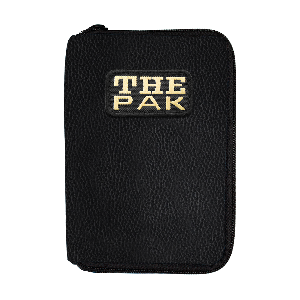 Die Abbildung zeigt die "The Pak Leder Edition Darttasche" in schwarzem Lederdesign. Auf der Vorderseite ist ein Aufnäher mit der Aufschrift "THE PAK" zu sehen.